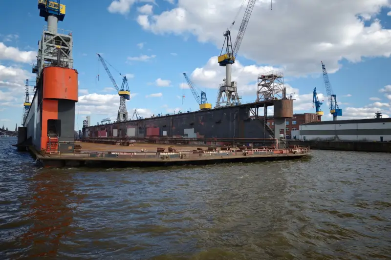 Floating dry dock with cranes in a shipyard
