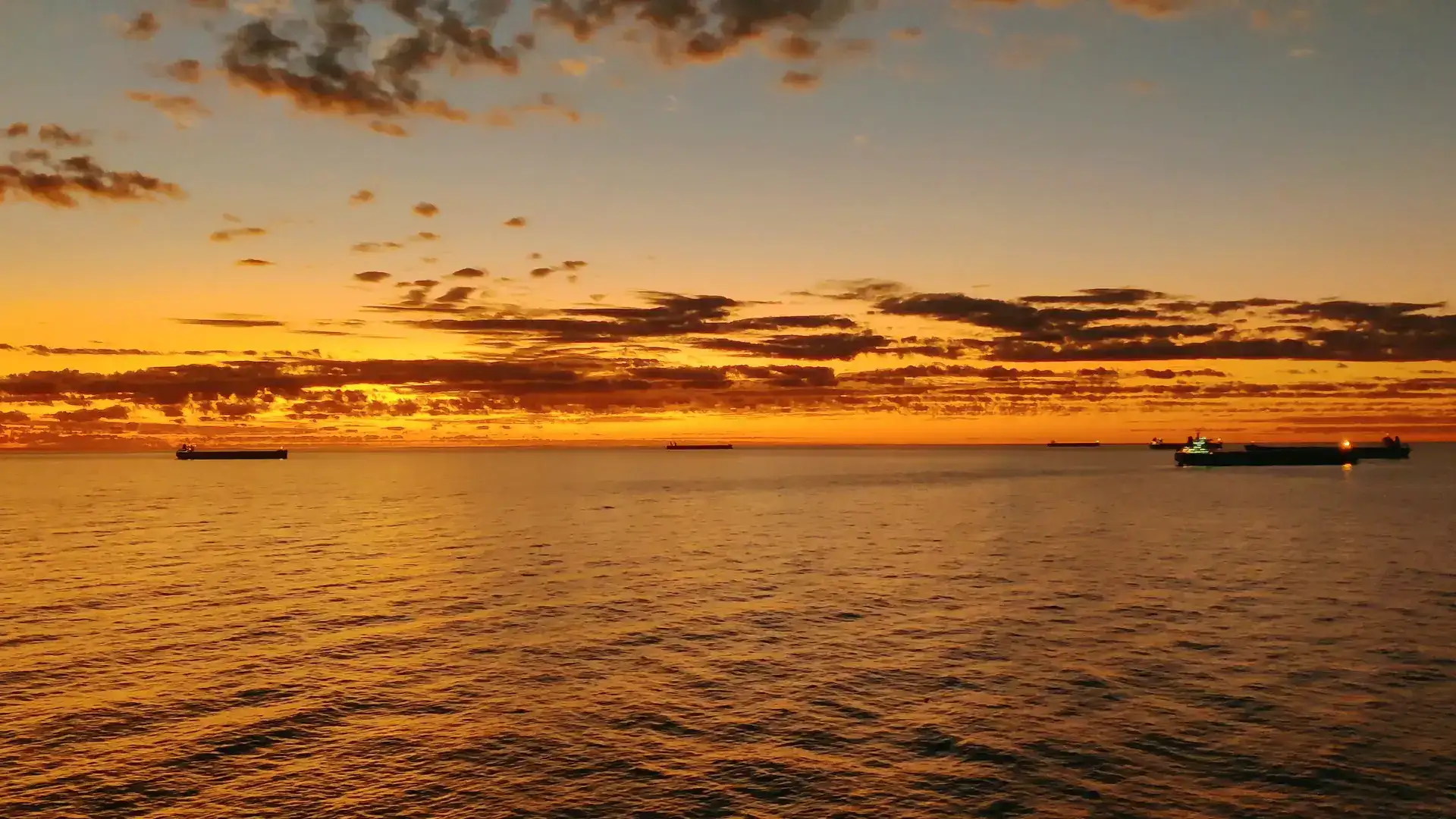 Cargo ship at sea at sunset